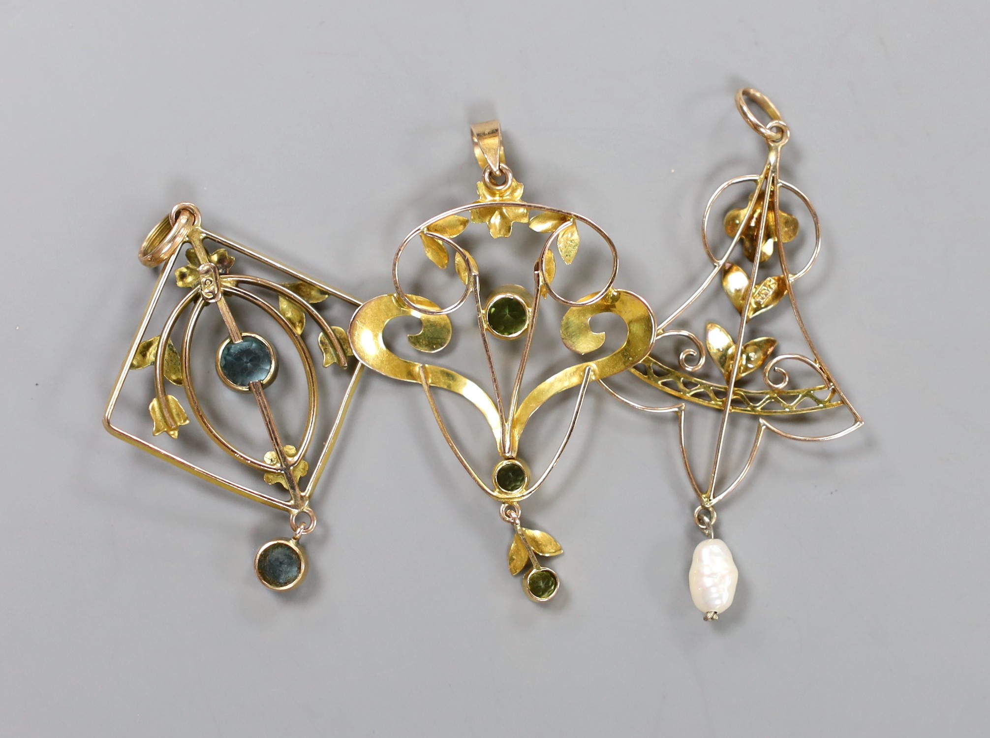 Three assorted Edwardian yellow metal and gem set pendants, including a 9ct and three stone peridot, 43mm, gross weight 5.9 grams.